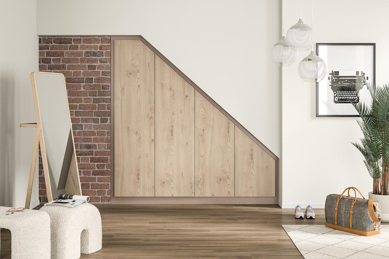 Massgefertigter Wandschrank aus hellem Holz in einer stilvollen Diele Ein grosser, eingebauter Wandschrank nach Mass mit hellen Holzfronten, integriert in eine Dachschräge neben einer Ziegelwand.