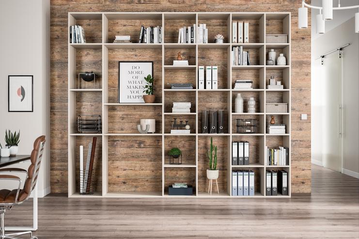 Geräumiges, grosses massgefertigtes Regal Ein grosses, helles Regal nach Mass, gefüllt mit Büchern und Dekorationen, vor einer Wand mit Holzoptik.