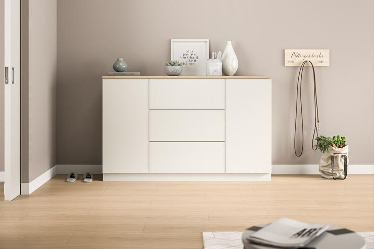 Schlichte Kommode nach Mass im modernen Eingangsbereich. Eine massgefertigte, weisse Kommode mit klaren Linien bietet diskreten Stauraum und eine minimalistische Ästhetik im Eingangsbereich des Hauses.