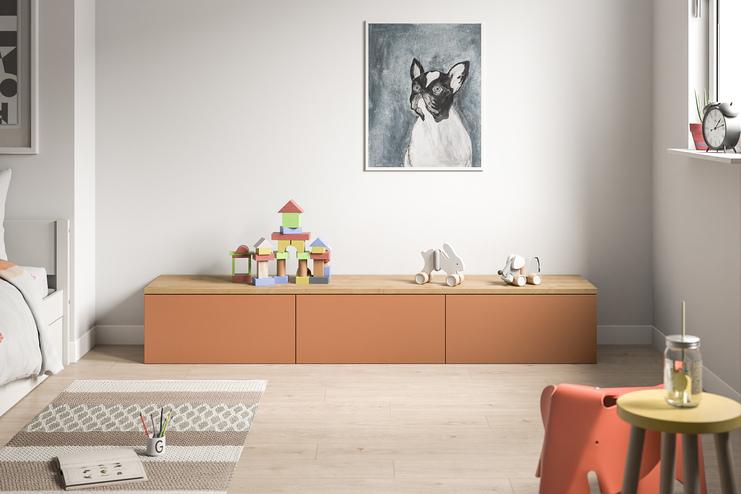 Farbige Kommode nach Mass in einem lebhaften Kinderzimmer. Eine moderne, terrakottafarbene Kommode nach Mass bietet mit ihrer glatten Oberfläche und geräumigen Schubladen einen kindgerechten Stauraum im Zimmer.
