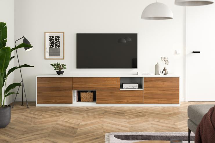 Elegante massgefertigte Kommode im modernen Wohnzimmer Eine minimalistische Kommode nach Mass, mit Holzelementen und weissen Fronten, steht unter einem Wand-TV, umgeben von stilvoller Dekoration.