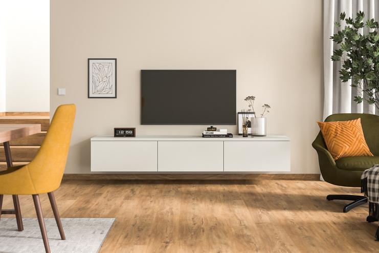 Modernes Hängeboard nach Mass unter Fernseher im stilvollen Wohnzimmer Ein massangefertigtes, wandmontiertes Hängeboard in schlichtem Weiss unter einem Wandfernseher, ergänzt durch zeitgenössische Deko und Grünpflanzen, fügt sich nahtlos in ein modernes Wohnambiente ein.